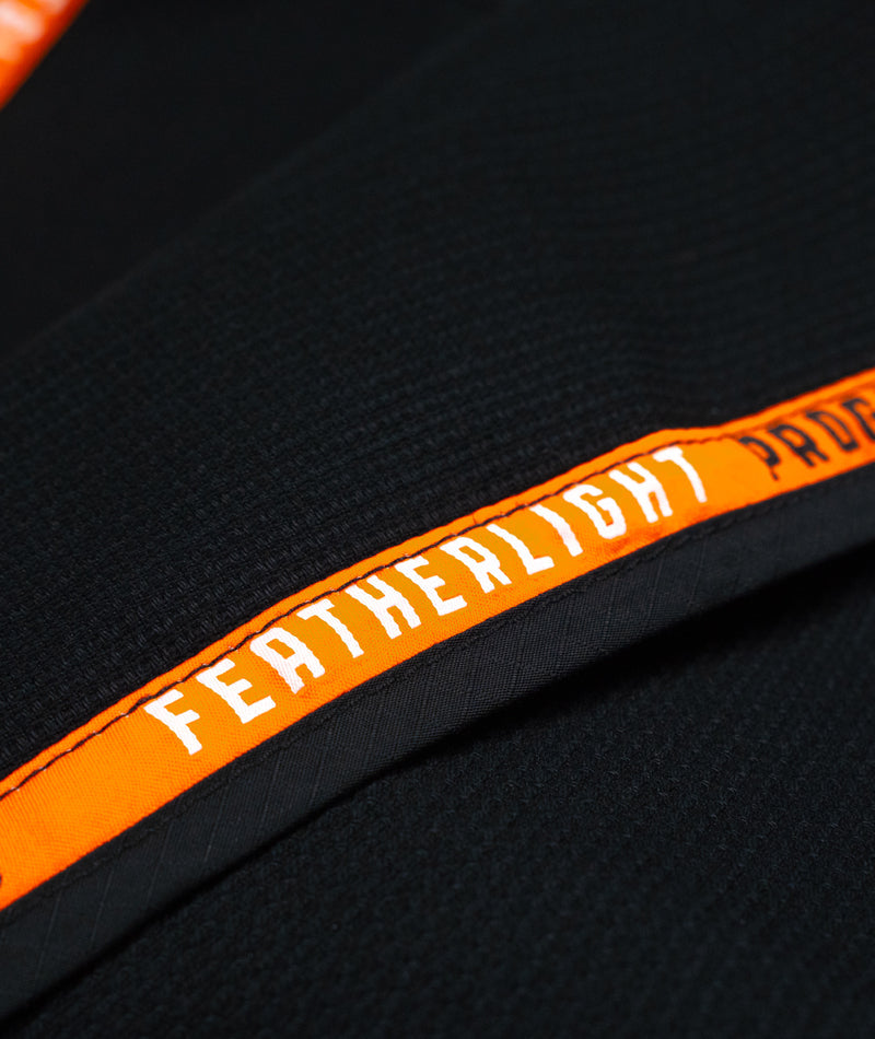 A close up image of the black Ladies Featherlight Lightweight Competition Kimono orange lining design