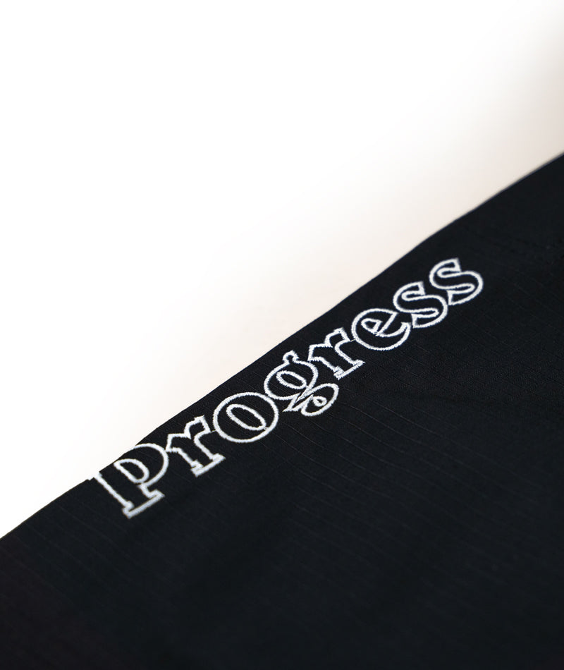 A close up view of the black Ladies Featherlight Lightweight Competition Pants Progress embroidery