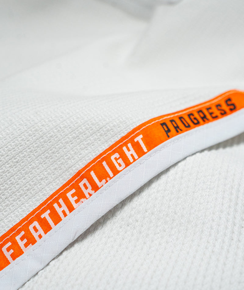 A close up image of the white Ladies Featherlight Lightweight Competition Kimono orange lining design