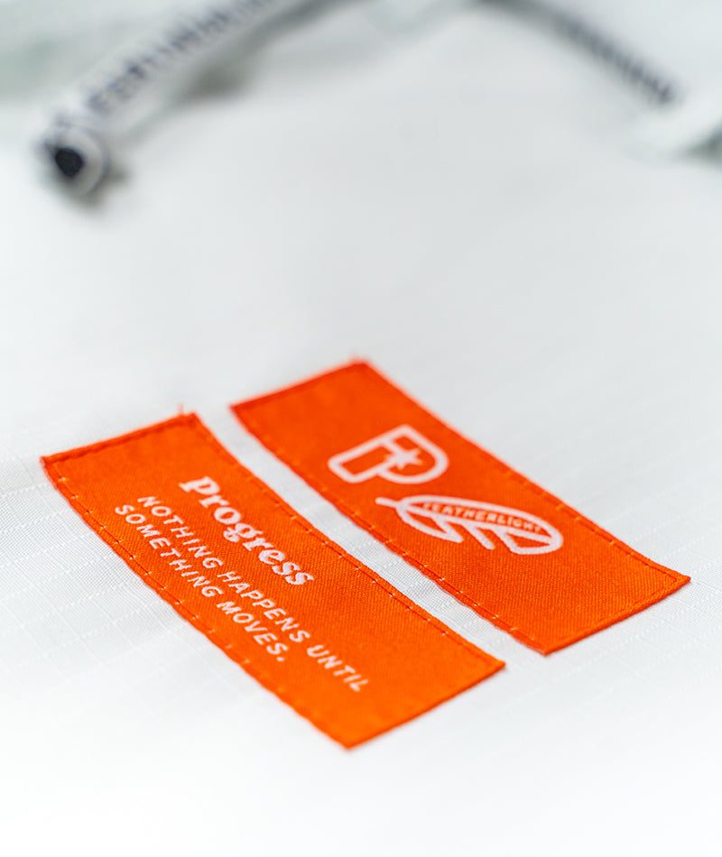 A close up image of the white Ladies Featherlight Lightweight Competition pants Progress brand patches